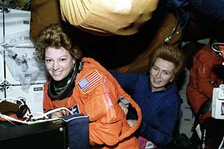 STS-84 Pilot Eileen Collins (left) and Mission Specialist Elena Kondakova prepare for Earth re-entry by suiting up in launch and entry suits (LES). 